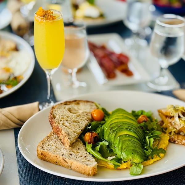 Avalon By Day brunch: omelet with avocado, arugula, roasted tomatoes, toast, and a mimosa.